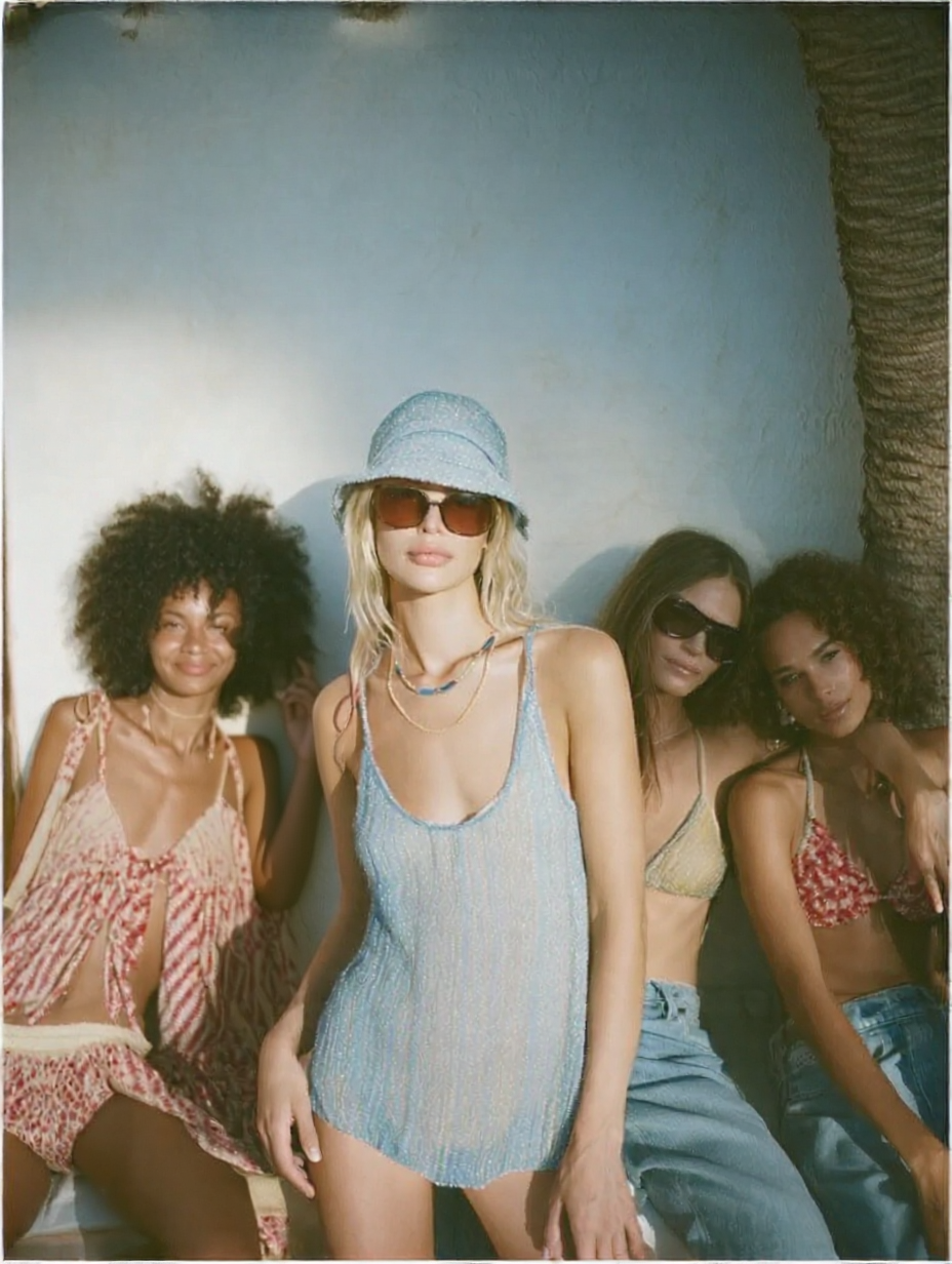 Four models posing together against a textured wall wearing Up My Alley jewelry.