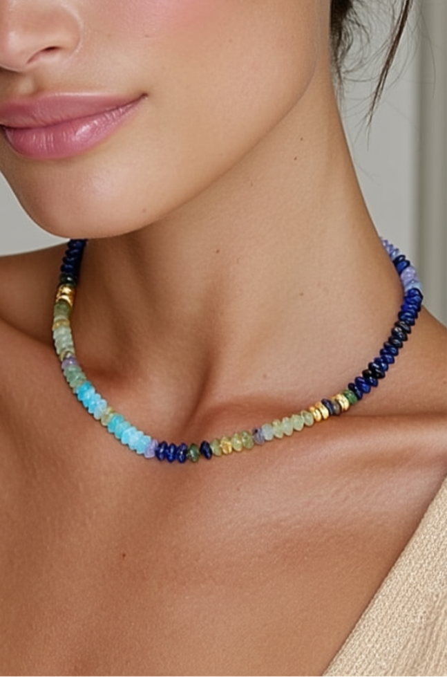 Model wearing the Dahlia Necklace – slim gold-plated necklace with multi-colored gemstone beads in deep blue, green, and aqua tones