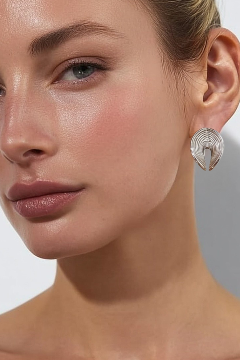 Model wearing the Elara Earrings – 14k white gold-plated textured fan-shaped earrings.