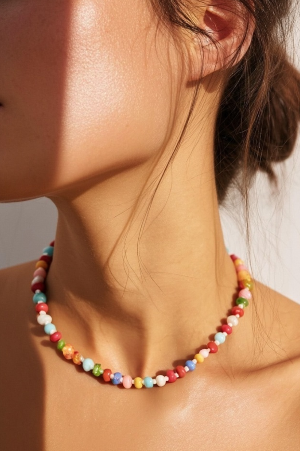 Model wearing the Marina Necklace – 14k yellow gold-plated chunky beaded necklace with high-gloss natural stone beads in mixed pink, coral, and warm neutral tones.