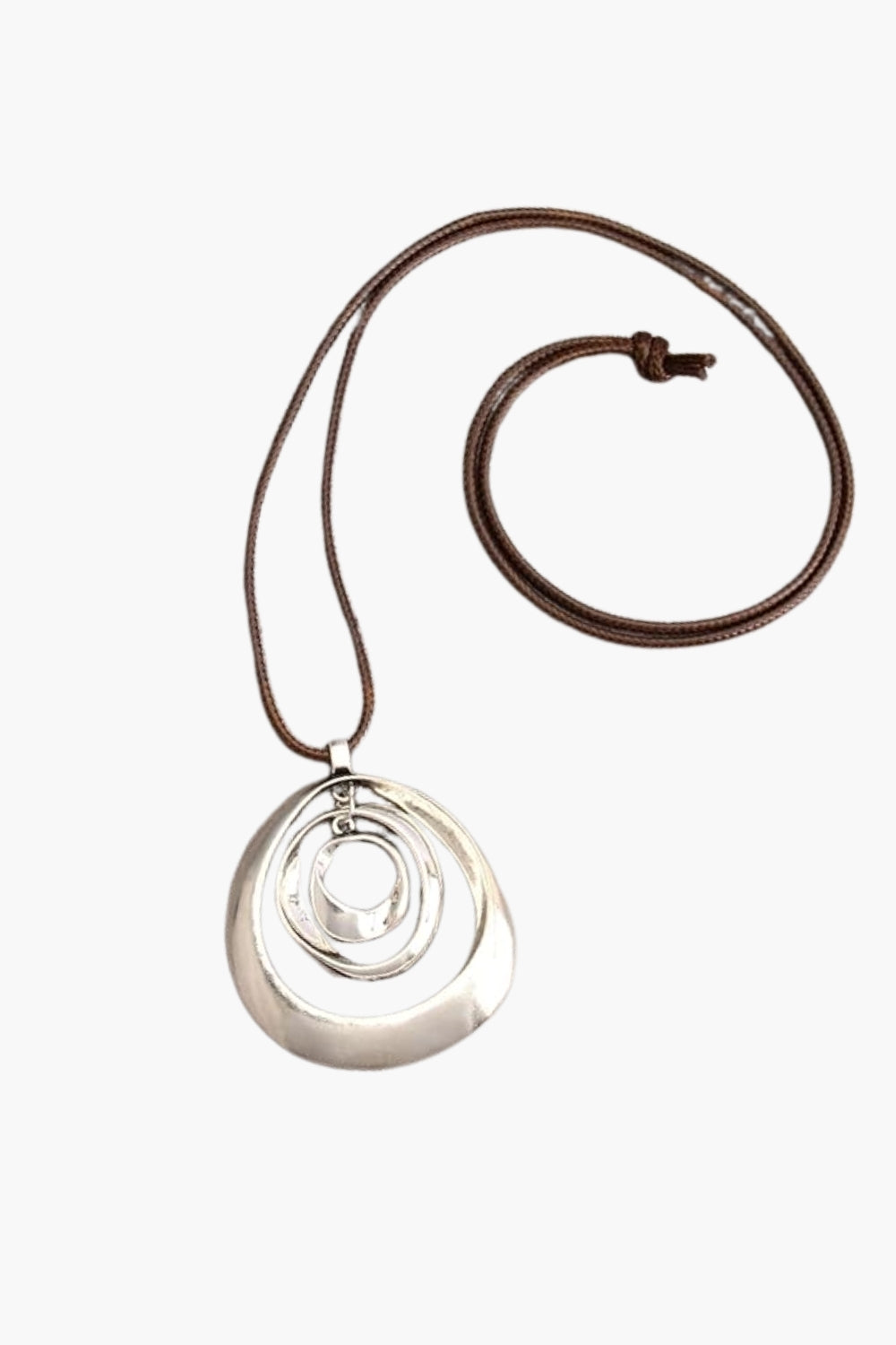 White gold pendant on a brown leather cord against a white background
