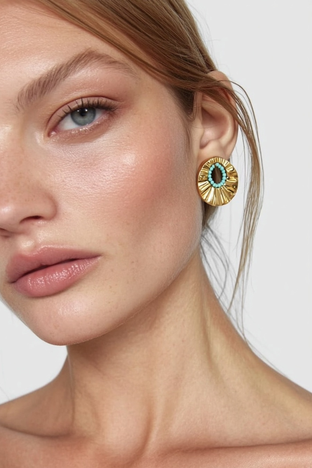 Model wearing the Arielle Earrings – 14k yellow gold-plated pleated disc earrings with turquoise bead center.