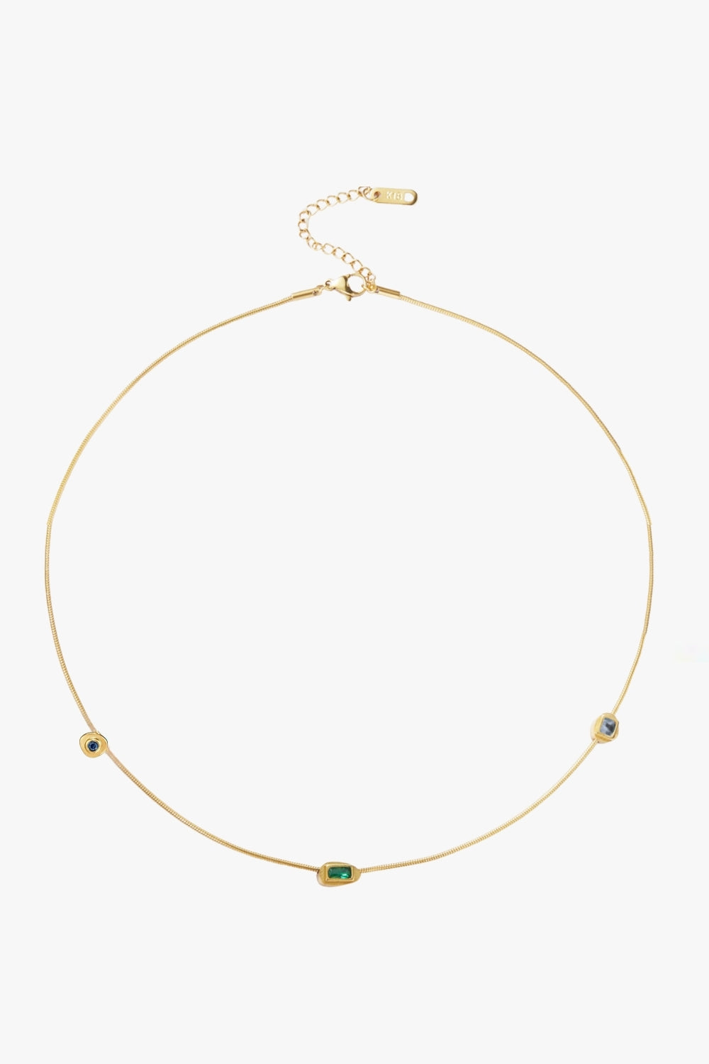 Yellow gold necklace with blue and green gemstones on a white background