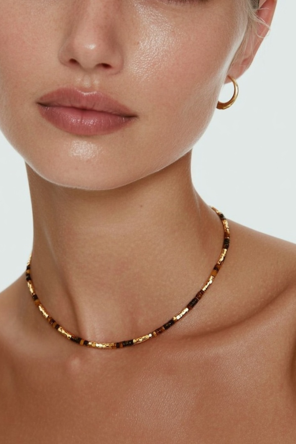 Model wearing the Lucia Necklace Sundown – slim gold-plated necklace with warm golden, amber, and chocolate gemstone beads