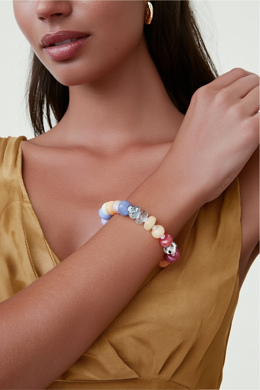 Model wearing the Marina Bracelet – 14k yellow gold-plated chunky beaded bracelet with high-gloss natural stone beads in vibrant fuchsia, red, and pink tones.