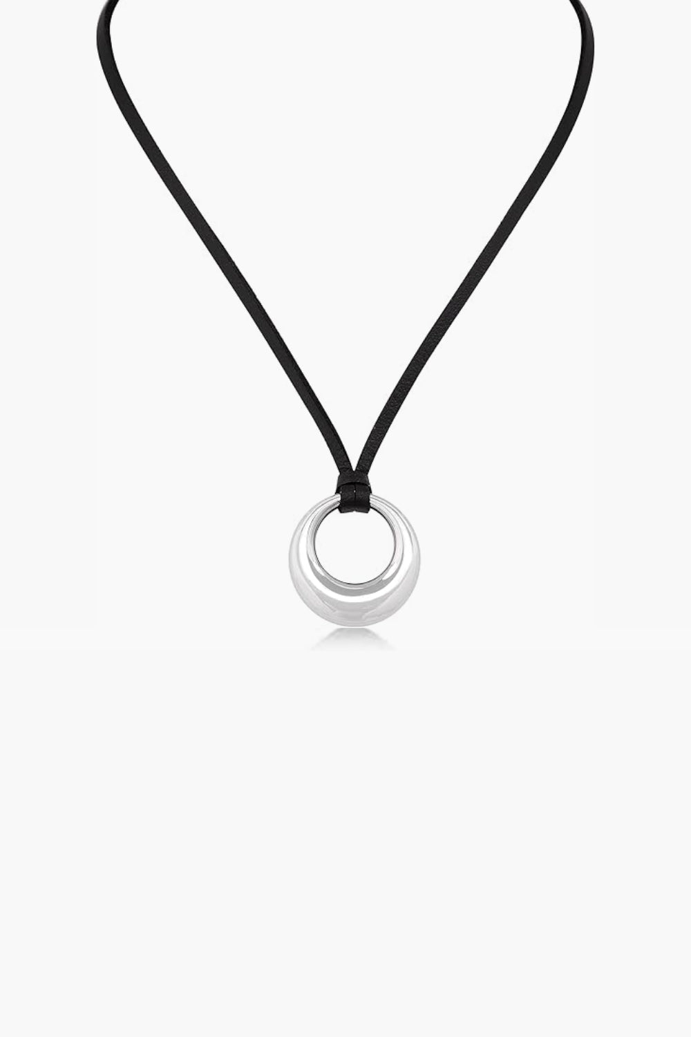 Necklace with a round white gold pendant and black cord against a white background.