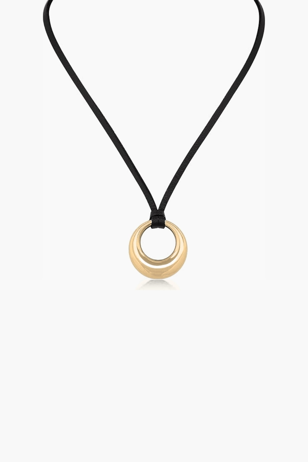 Yellow gold necklace with round pendant a black cord on a white background