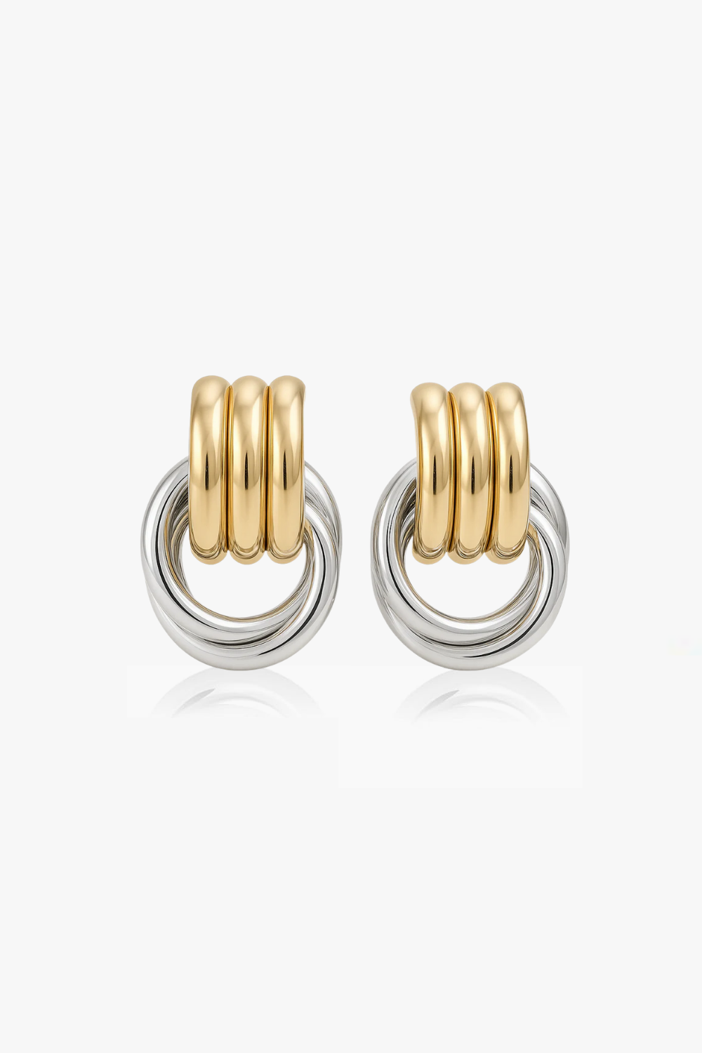 Chunky layered yellow gold and white gold hoop earrings on a white background