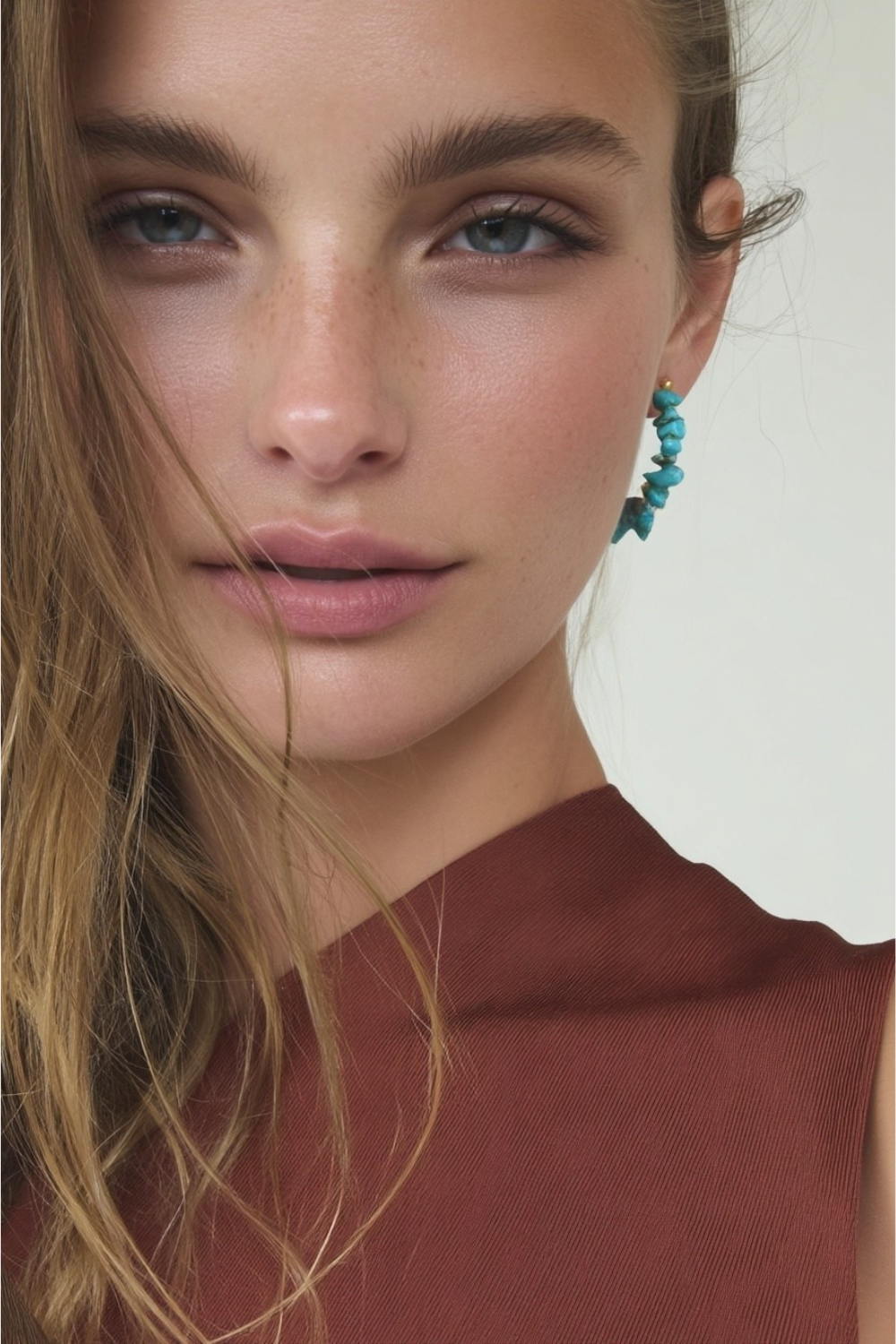Model wearing the Thalia Earrings – 14k yellow gold-plated hoop earrings with natural turquoise chip beads.