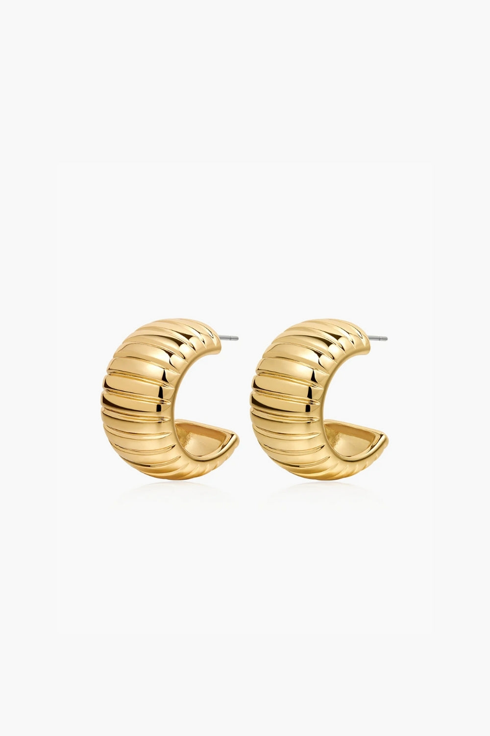 Yellow gold hoop earrings, ribbed, on a white background