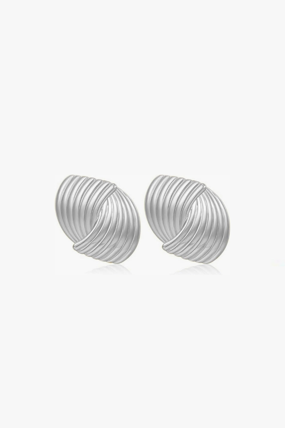 pair of vintage, ribbed white gold stud earrings on a white background.